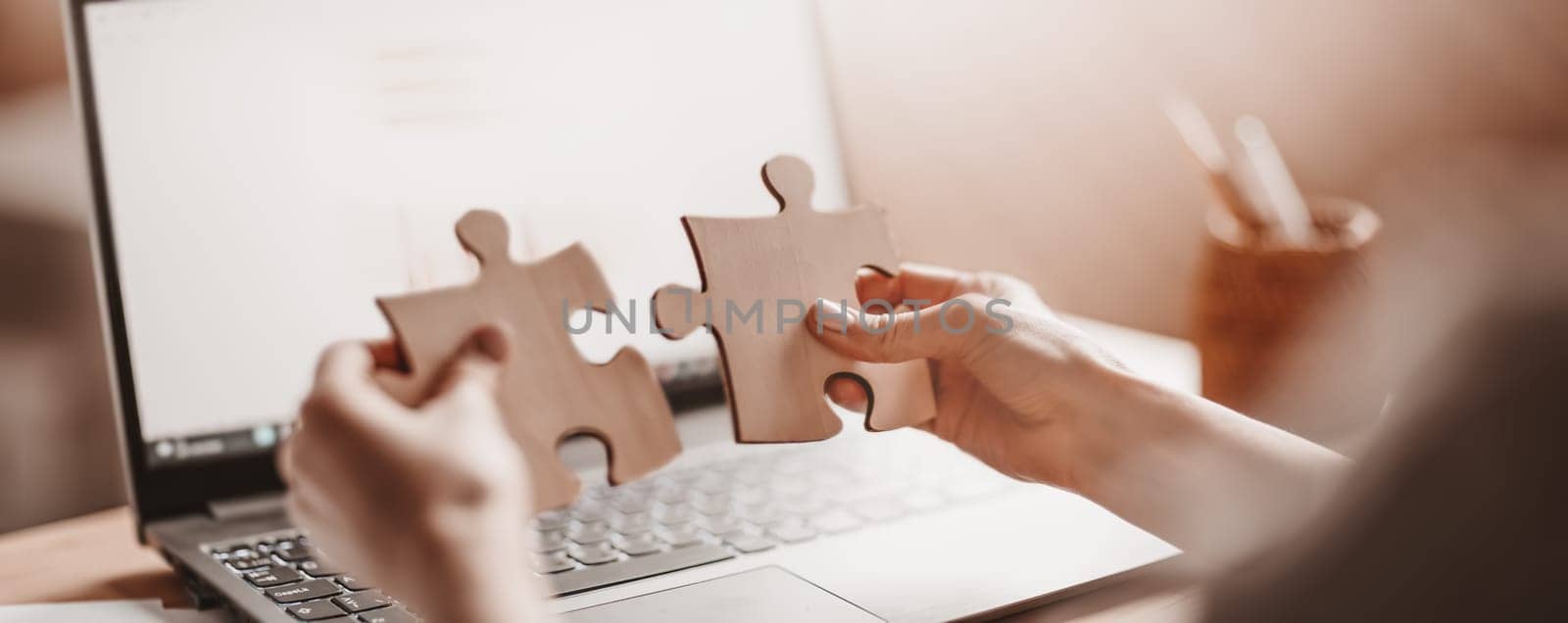 Woman holding pieces of puzzle in the office. Concept of solving problems and working together in company.