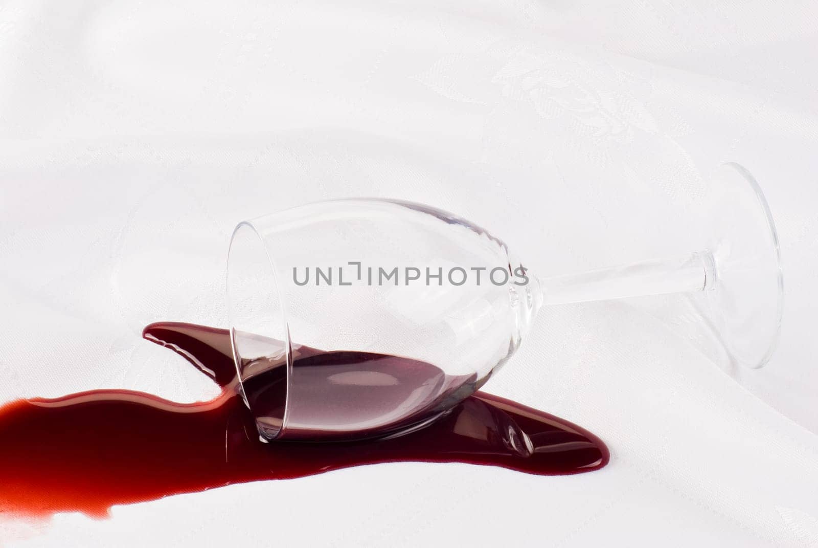 Glass of wine overthrow on the table cloth