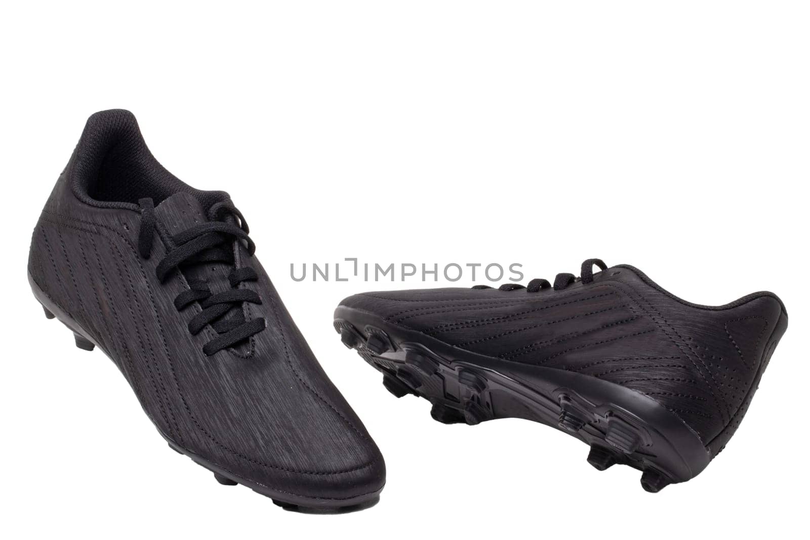 Closeup of a pair of black leather football boots isolated on white background. Professional athletics boys outdoor training shoes. Sports shoes.