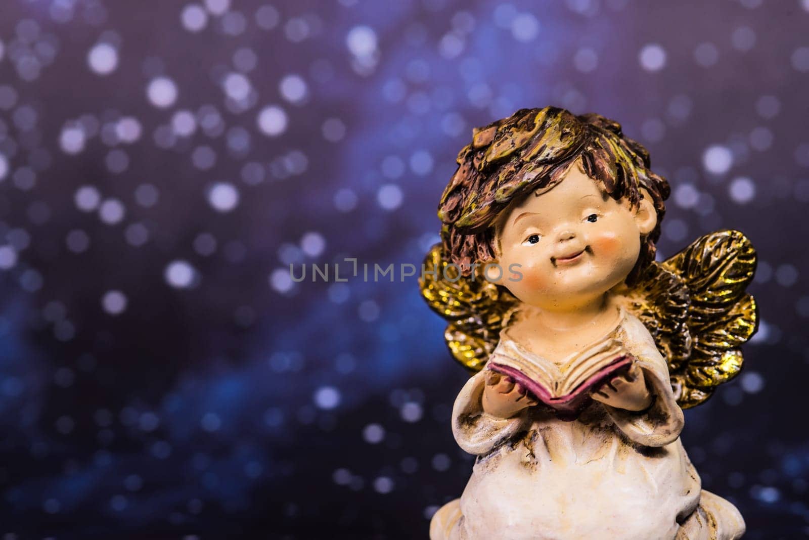 angel with a book on a night sky with stars