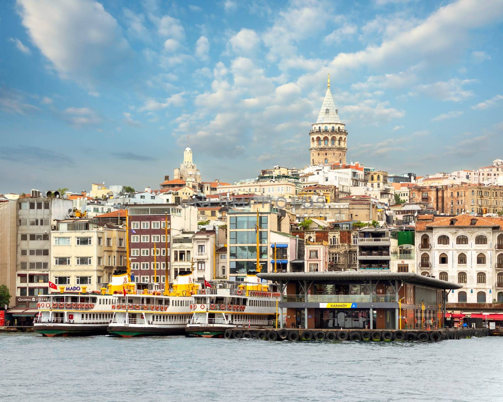 City view of Istanbul skyline, from the Bosporous strait overlooking Galata Tower, Karakoy ferry terminal, and docked ferry boats, Istanbul, Turkey