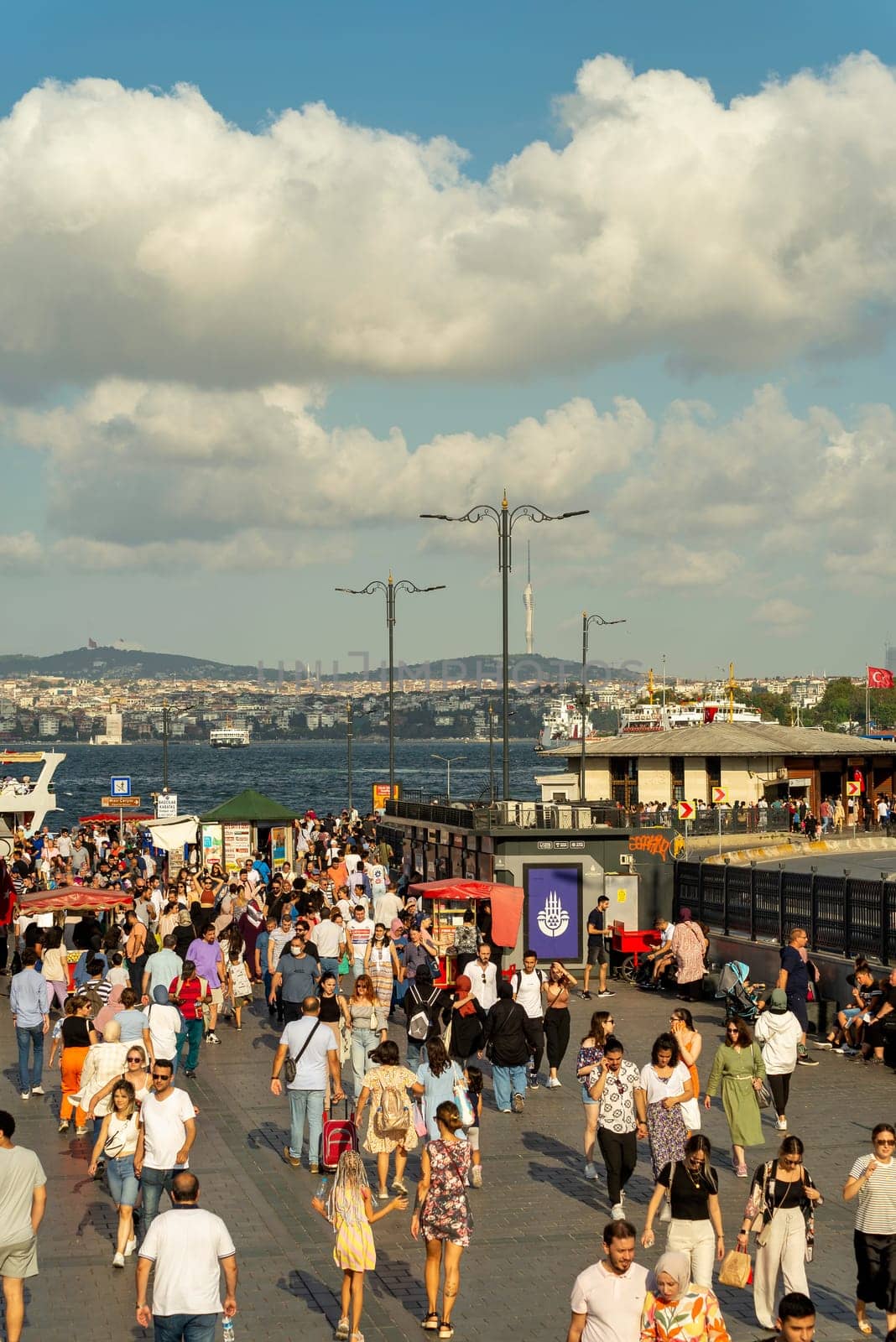 Istanbul, Turkey - August 30, 2022: Crowds of local citizens and tourists at Eminonu Piazza during the Victory Day holiday with background of Istanbul city view