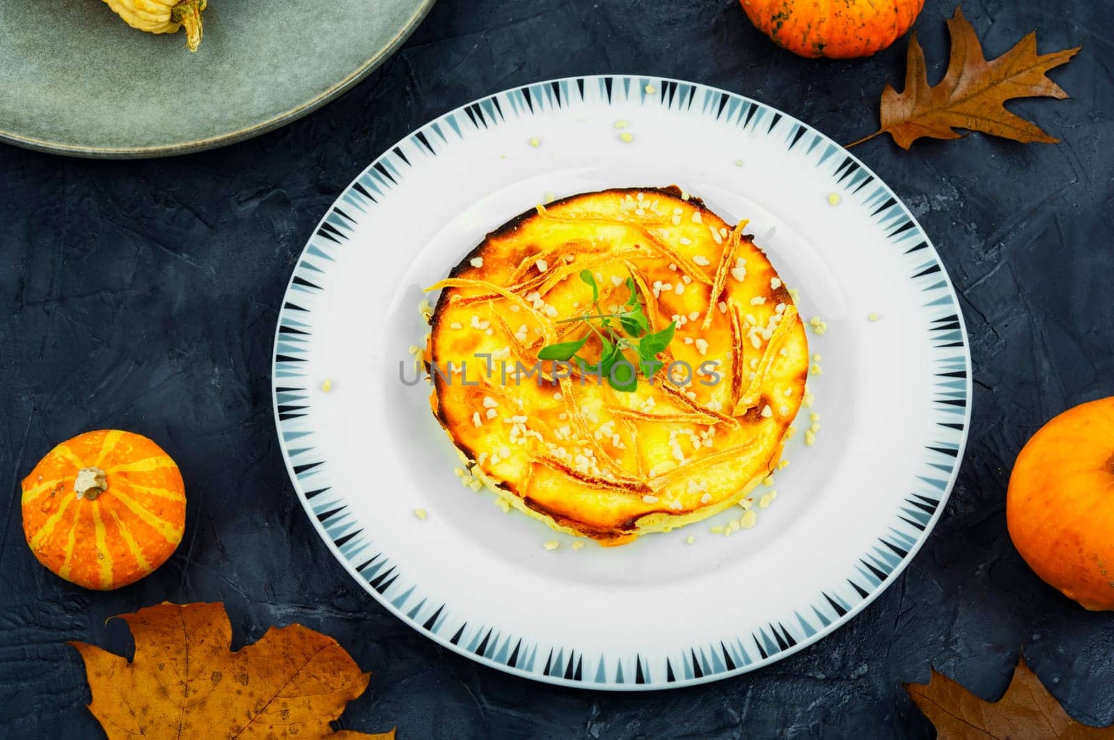 Homemade cakes, autumn recipe. Cottage cheese pumpkin casserole decorated with orange peels.