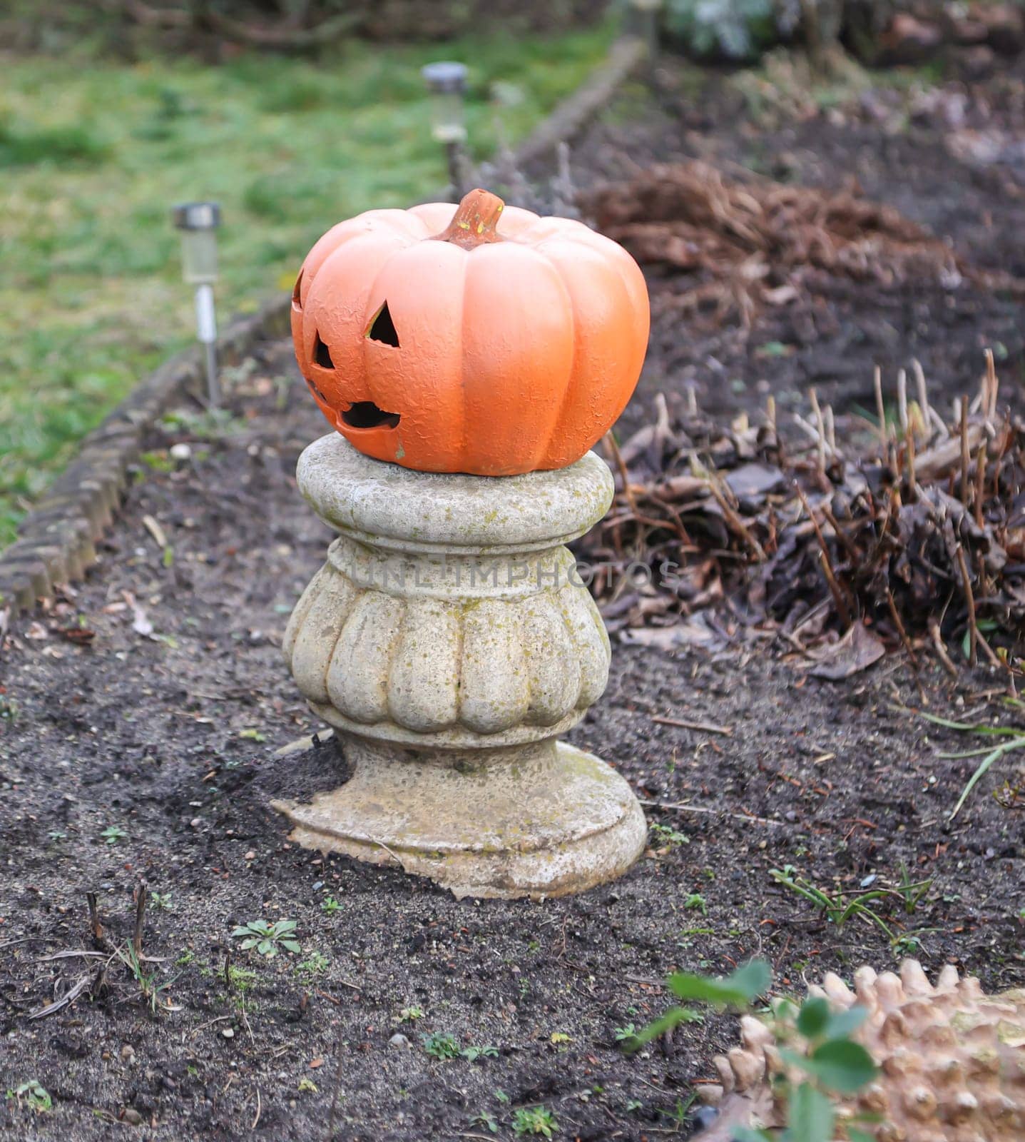 A Halloween decoration on a pedestal in the garden.