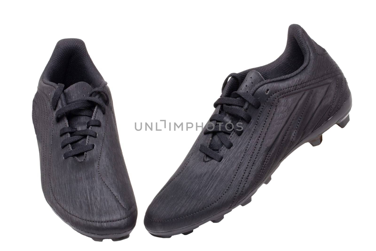 Closeup of a pair of black leather football boots isolated on white background. Professional athletics boys outdoor training shoes. Sports shoes.