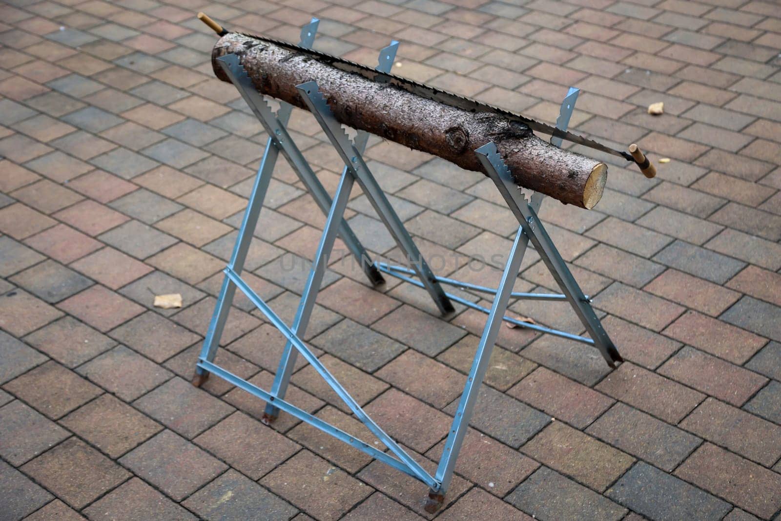 Details of a sawhorse with log and saw at a wedding.
