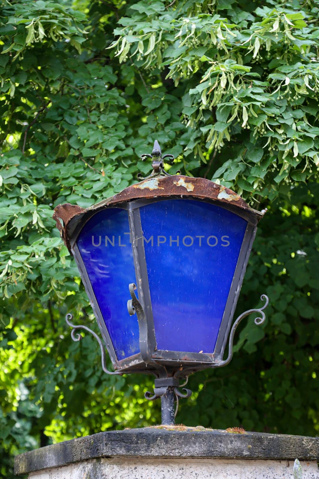 A lantern with blue discson a gatepost.