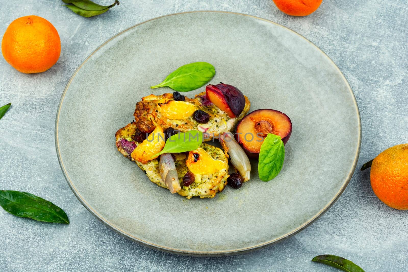 Prepared pork chop cooked with plums and tangerine. Baked meat steak meat in sweet fruits sauce
