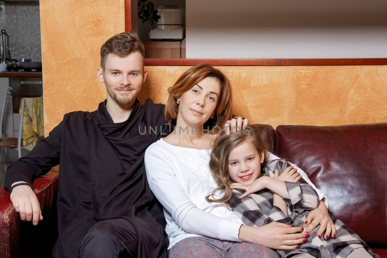Portrait of happy family giving a hug sitting on sofa