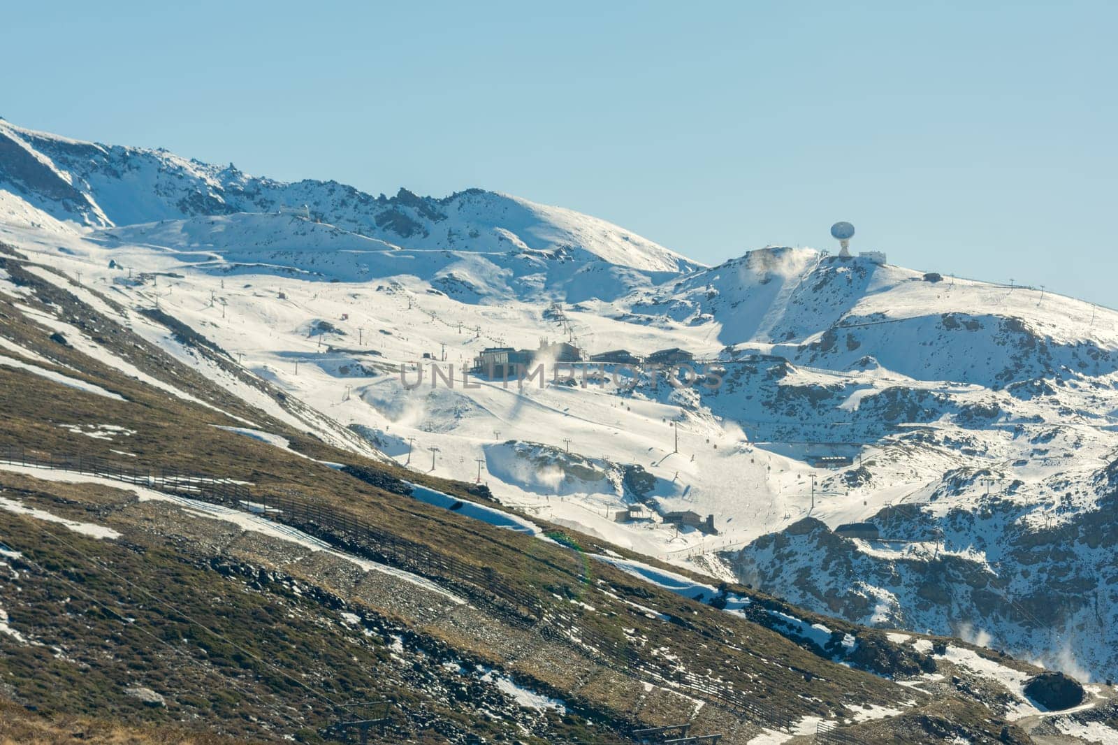 View of the ski resort in the high snowy mountains in winter with clear weather and bright snow.