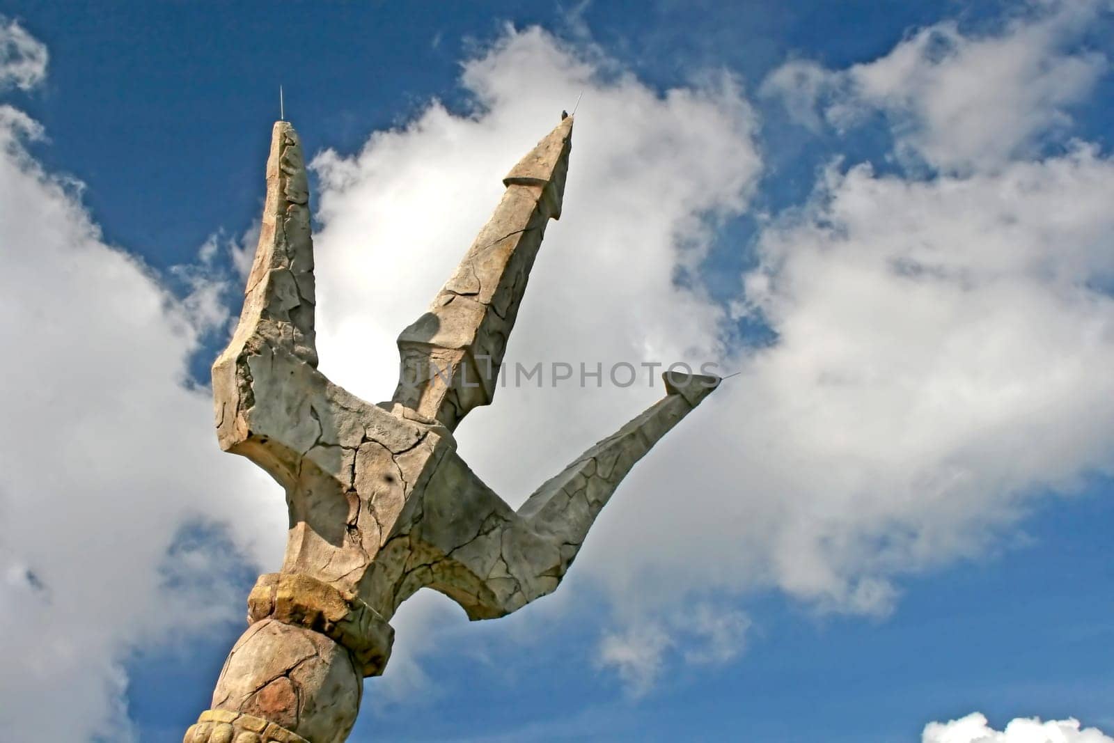A stone trident with sky and clouds