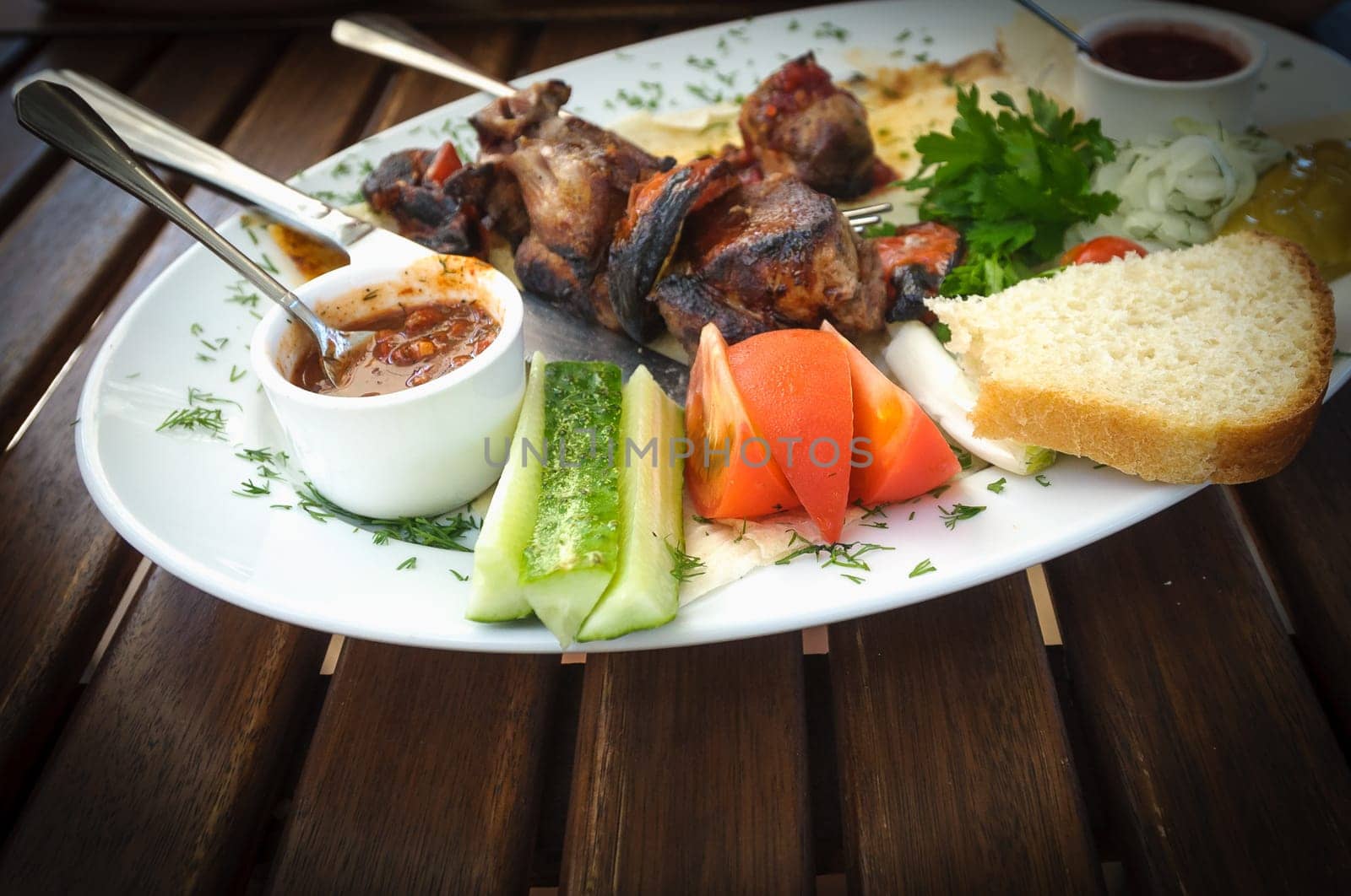Nice and tasty dish of roasted meat with vegetables and souces