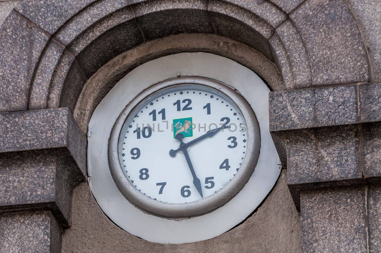 Clock on a wall with kharkov town in ukraine symbol