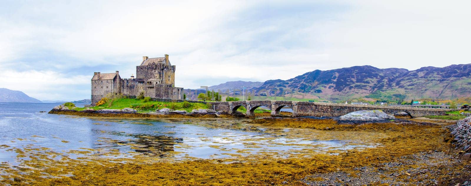 Panoramic view of famous Eilean Donan Castle in Scotland, UK. Situated on a small isle at the meeting point of three sea lochs - Loch Long, Loch Duich and Loch Alsh, is one of the most iconic images of Scotland.