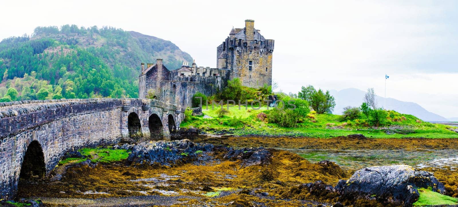 Panoramic view of famous Eilean Donan Castle in Scotland, UK. Situated on a small isle at the meeting point of three sea lochs - Loch Long, Loch Duich and Loch Alsh, is one of the most iconic images of Scotland.