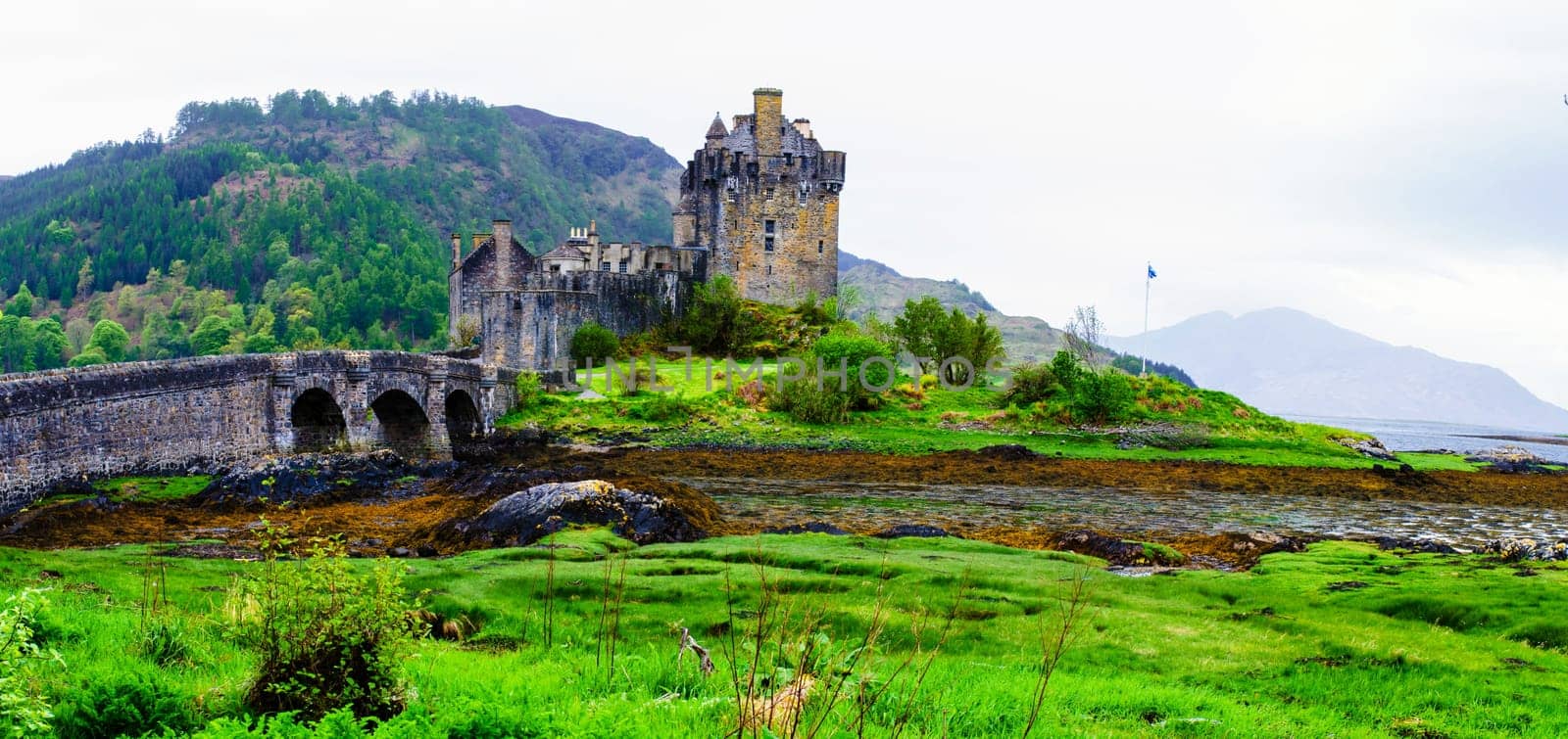 Panoramic view of famous Eilean Donan Castle in Scotland, UK. Situated on a small isle at the meeting point of three sea lochs - Loch Long, Loch Duich and Loch Alsh, is one of the most iconic images of Scotland.
