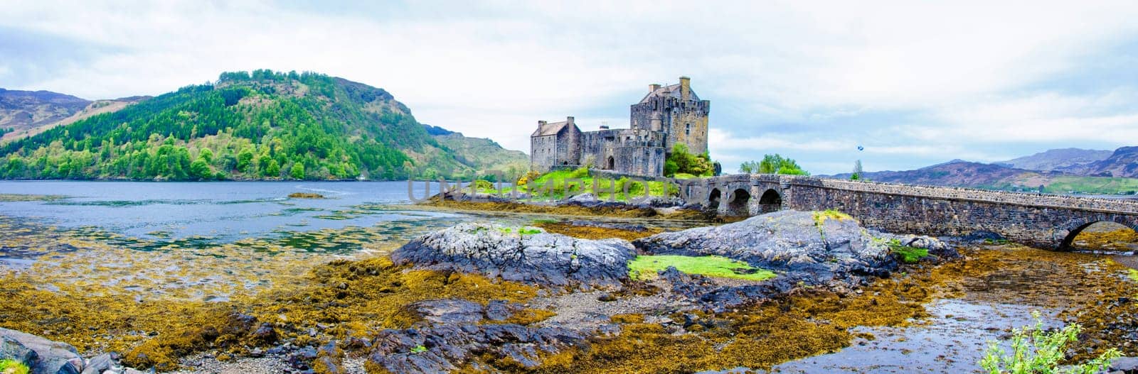 Panoramic view of famous Eilean Donan Castle in Scotland, UK. Situated on a small isle at the meeting point of three sea lochs - Loch Long, Loch Duich and Loch Alsh, is one of the most iconic images of Scotland.