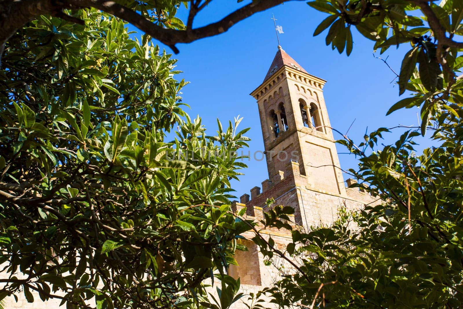 Saints Joseph and Christoper church, Bolgheri Tuscan IT- November 2, 2014. View through the trees of a medieval church.