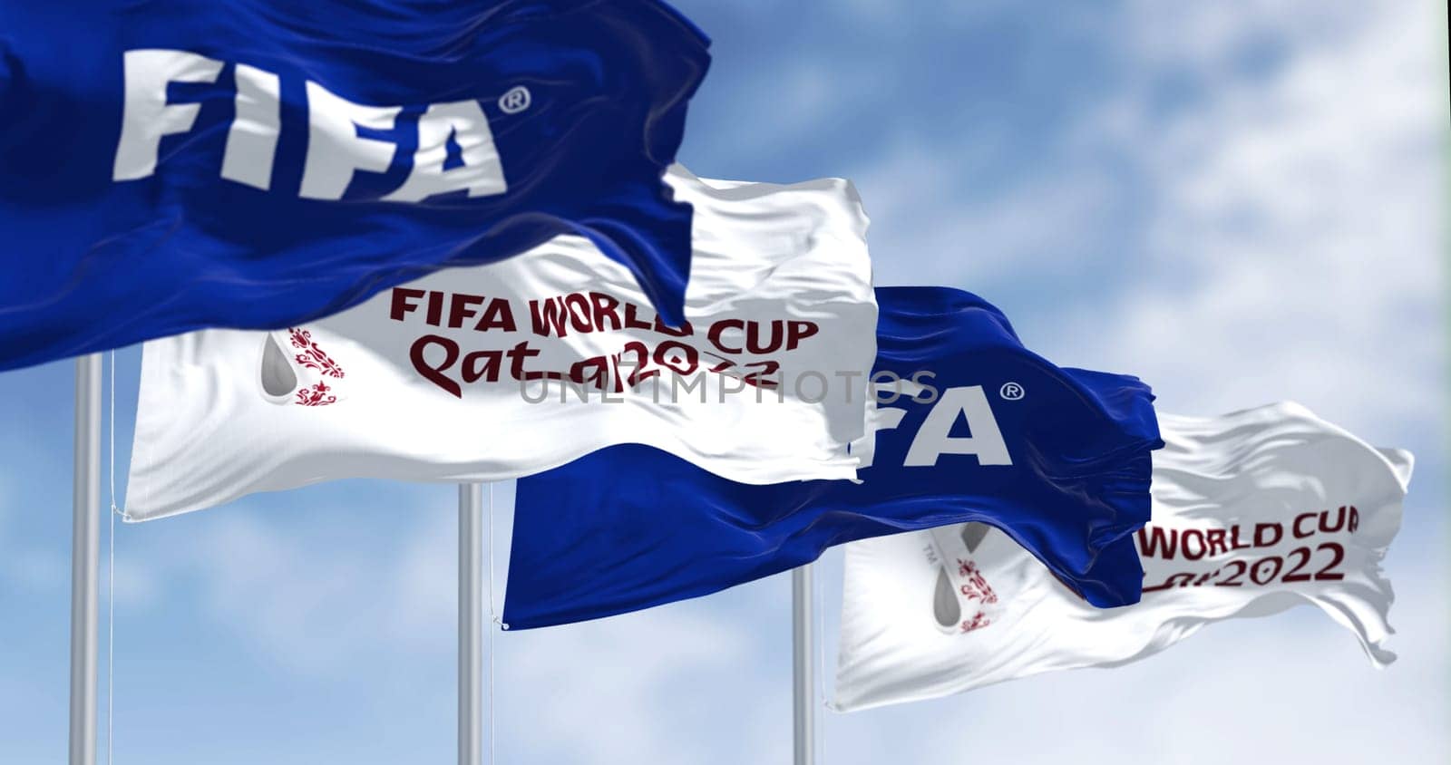 Doha, QA, nov 2022: Flags with FIFA and Qatar 2022 World Cup logo waving in the wind. The event is scheduled in Qatar from 21 November to 18 December 2022