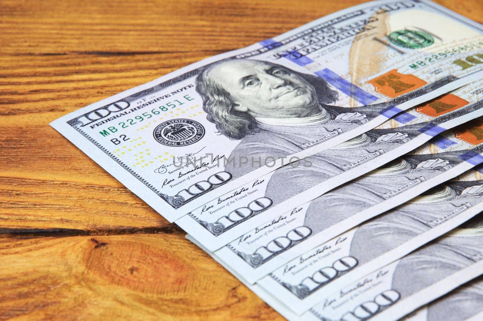 Dollars in a row diagonally on wooden boards.