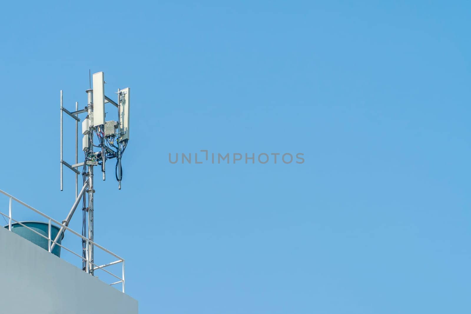 Cellular phone towers are on the rooftop of the building.