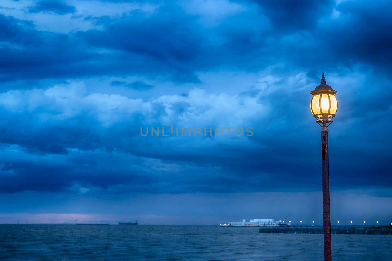 Light Post at nigth near sea with stom background
