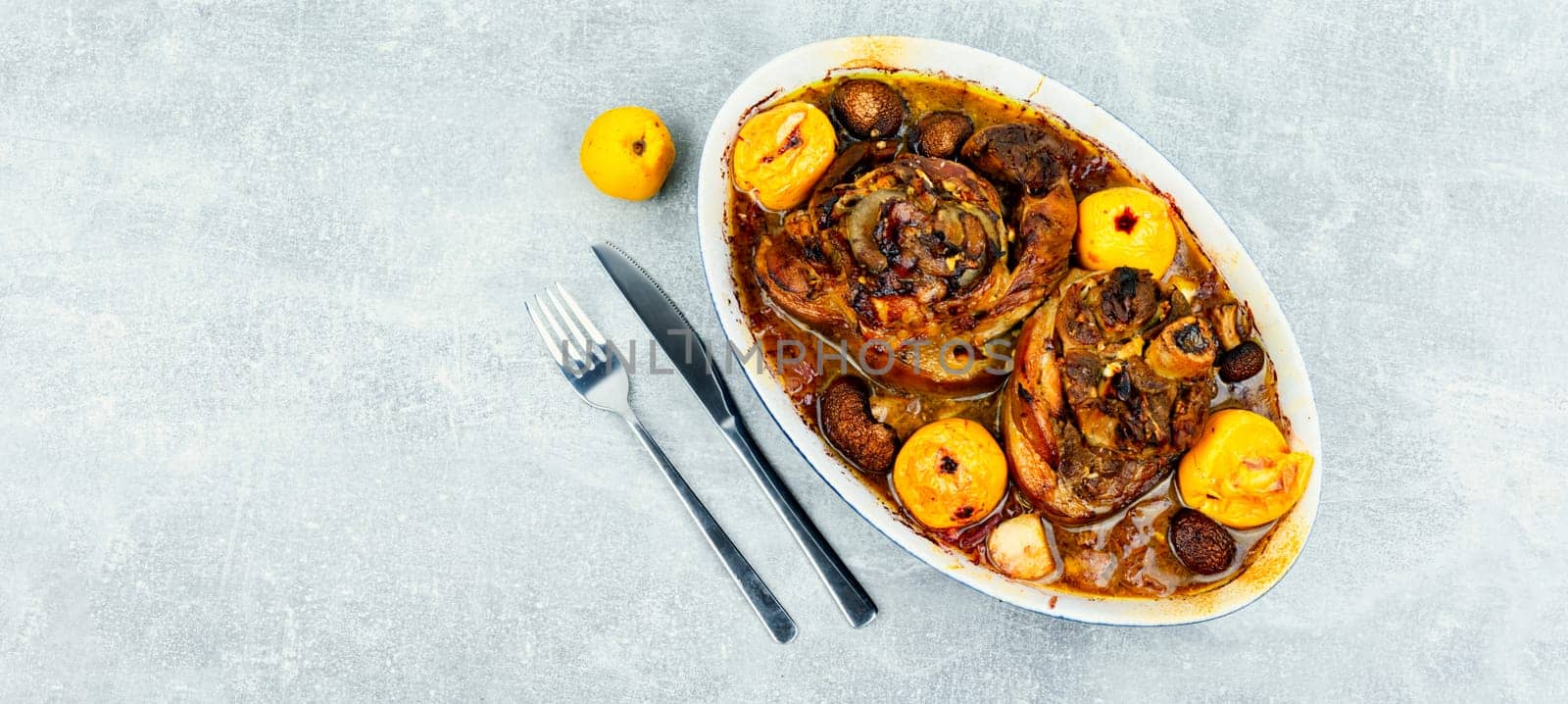 Traditional pork knuckle cooked in dark beer, sauerkraut and apples. German recipe.