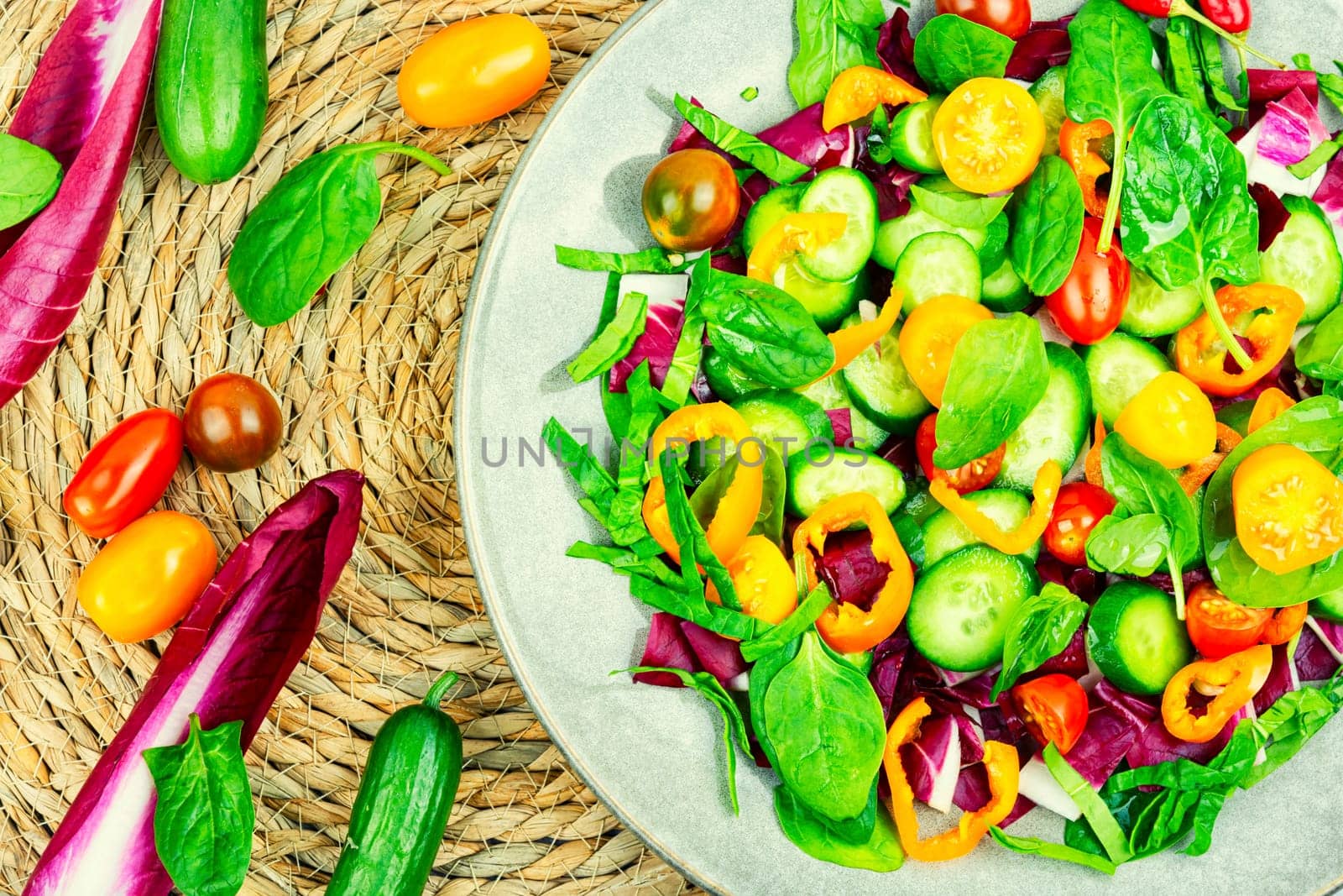 Summer delicious salad of tomatoes, cucumbers, peppers and spinach.