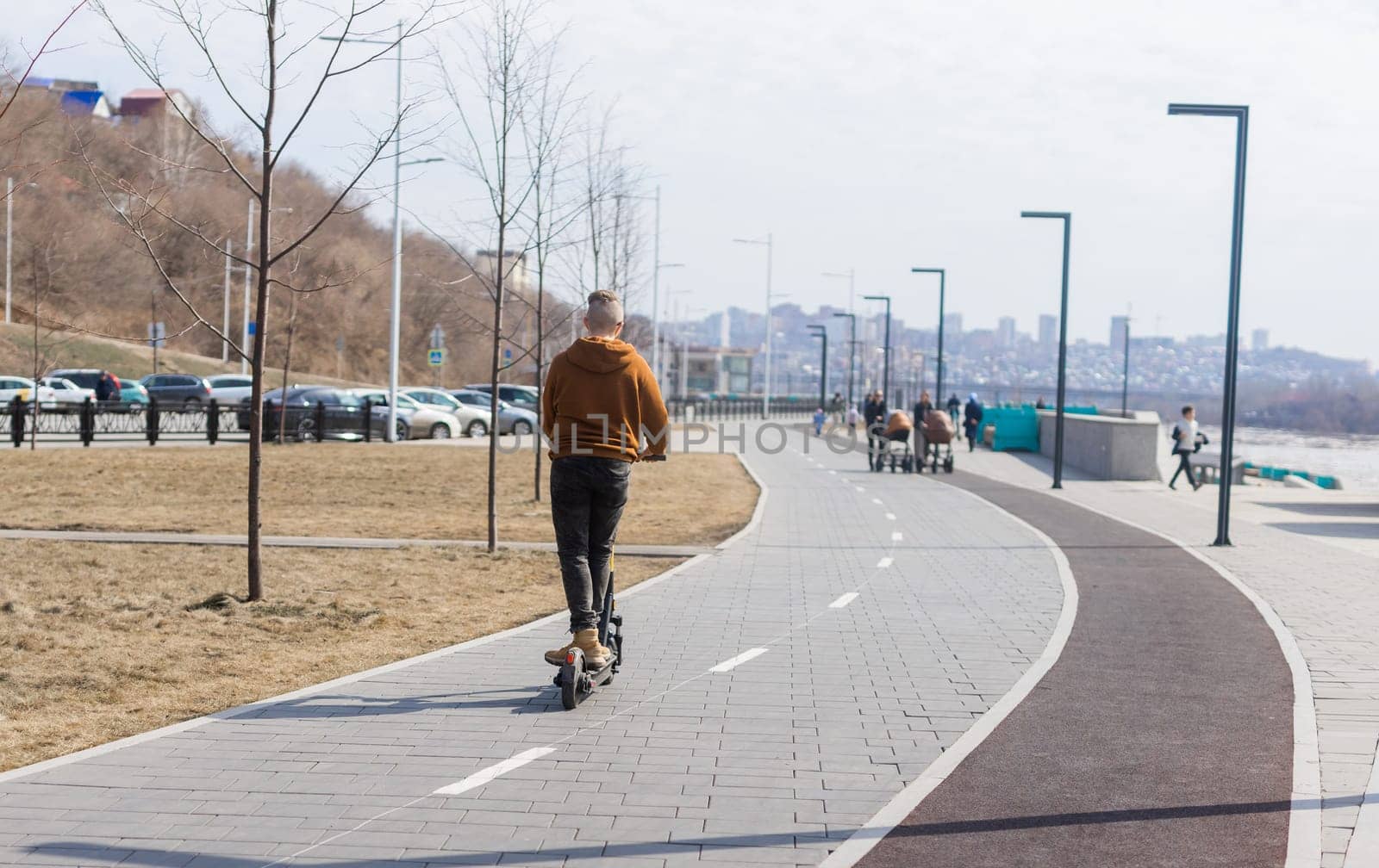 Modern guy riding by electric scooter in the city. Innovative transport and lifestyle