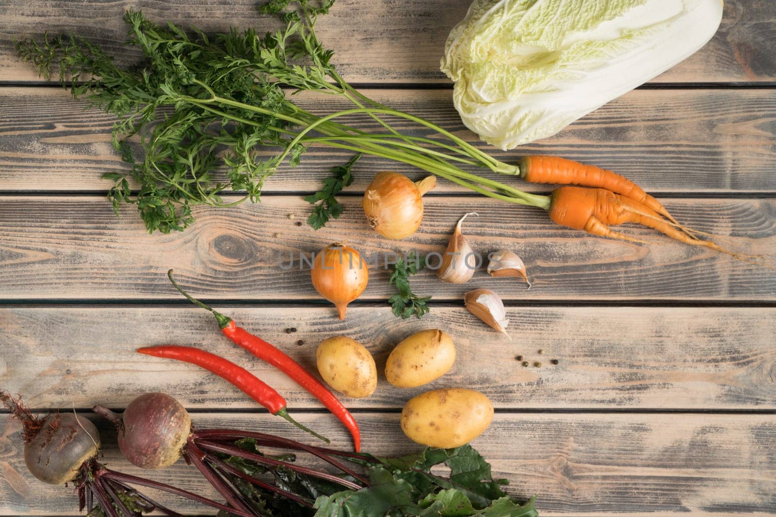 Vegetable food composition of onion, cabbage, beet root, chili pepper, carrot, potato and garlic on wooden table background. Healthy eating and cooking recipe. Top view, flat lay, copy space