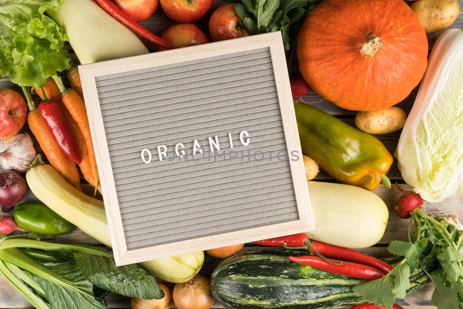 Vegetable, fruit food variety with nameplate organic on onion, zucchini, apple, pumpkin, cabbage, carrot, pepper, tomato, garlic, potato. Homegrown produce, organic consumption. Full frame, top view