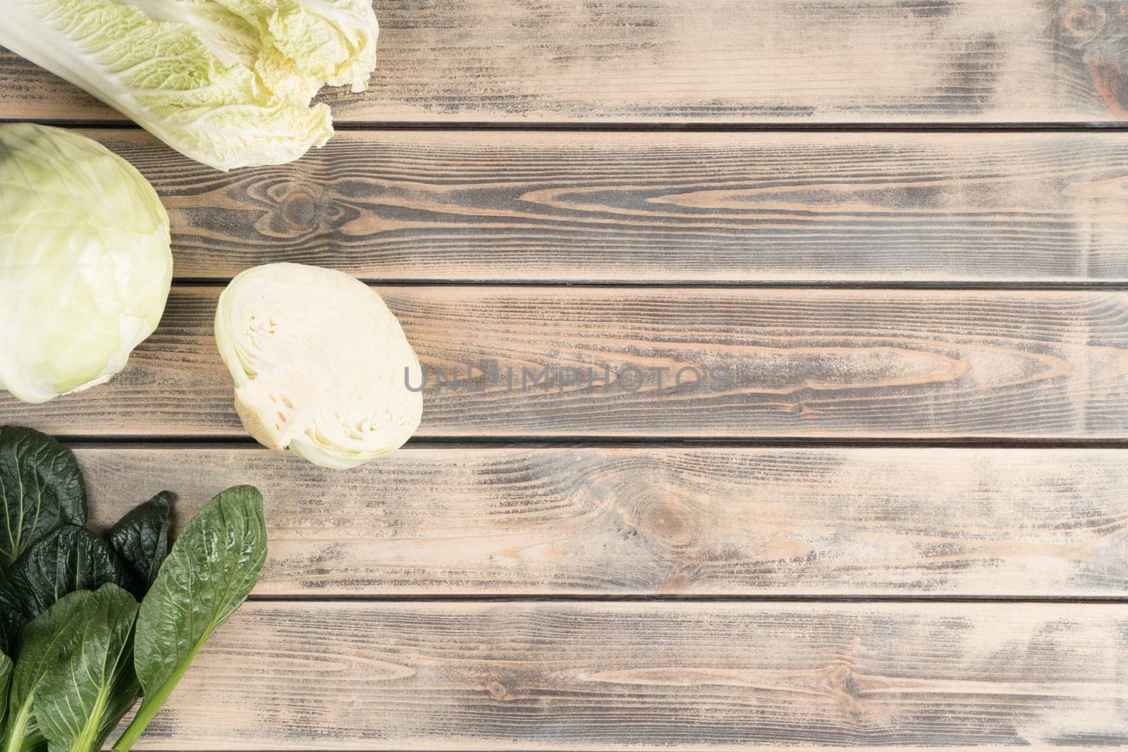 Food mockup of slices of cabbage with lush foliage on wooden background. Advertisement for natural, organic food store, market. Healthy nutrition and diet. Farm meal. Top view, template, copy space