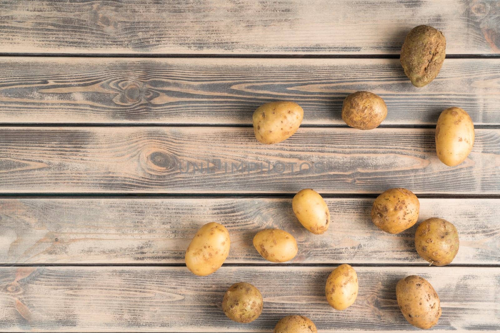 Organic farm potato bulbous on wooden background. Farm, raw food and healthy eating. Tasty and delicious products for market or store. Autumn harvest, seasonal food. Top view, copy space, flat lay