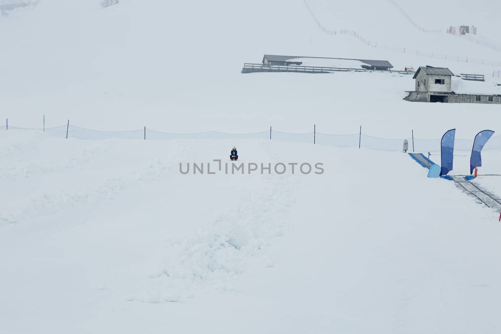 Mom and baby enjoy a sleigh ride. Sledding for children. Child riding a sleigh. Children play outdoors in the snow. Outdoor fun for family Christmas holidays. soft focus.