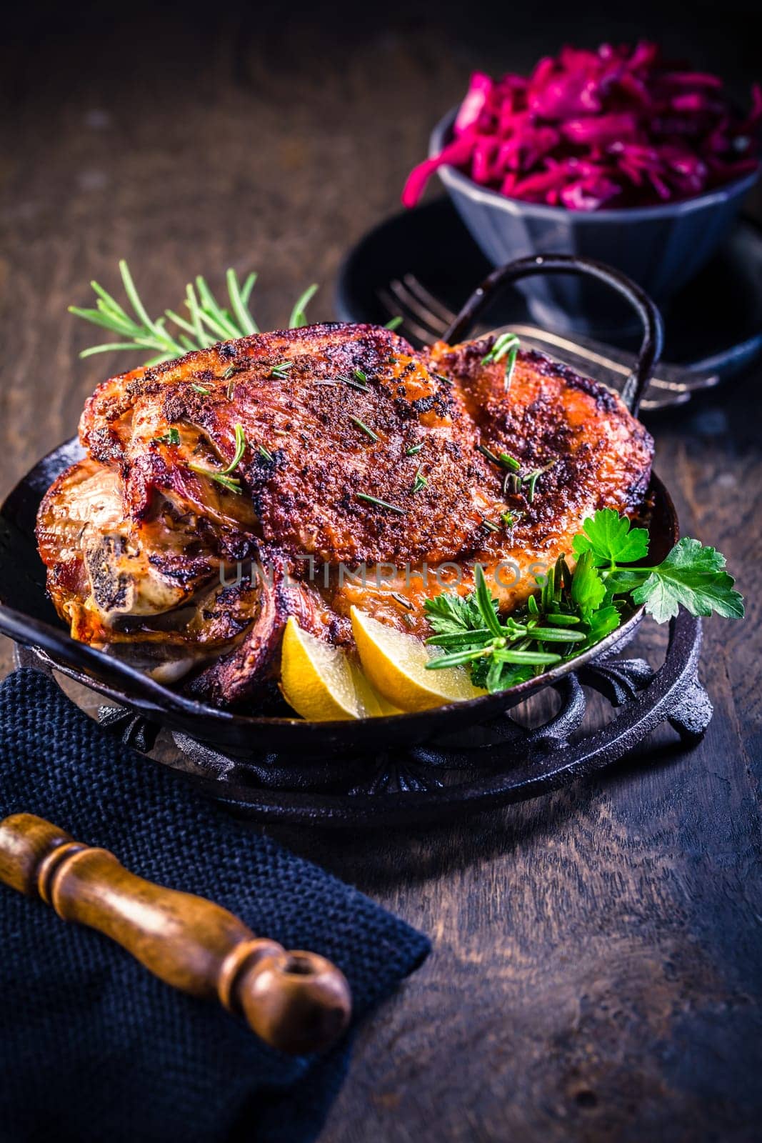 Roasted turkey knuckle with pickled red cabbage salad on wooden background