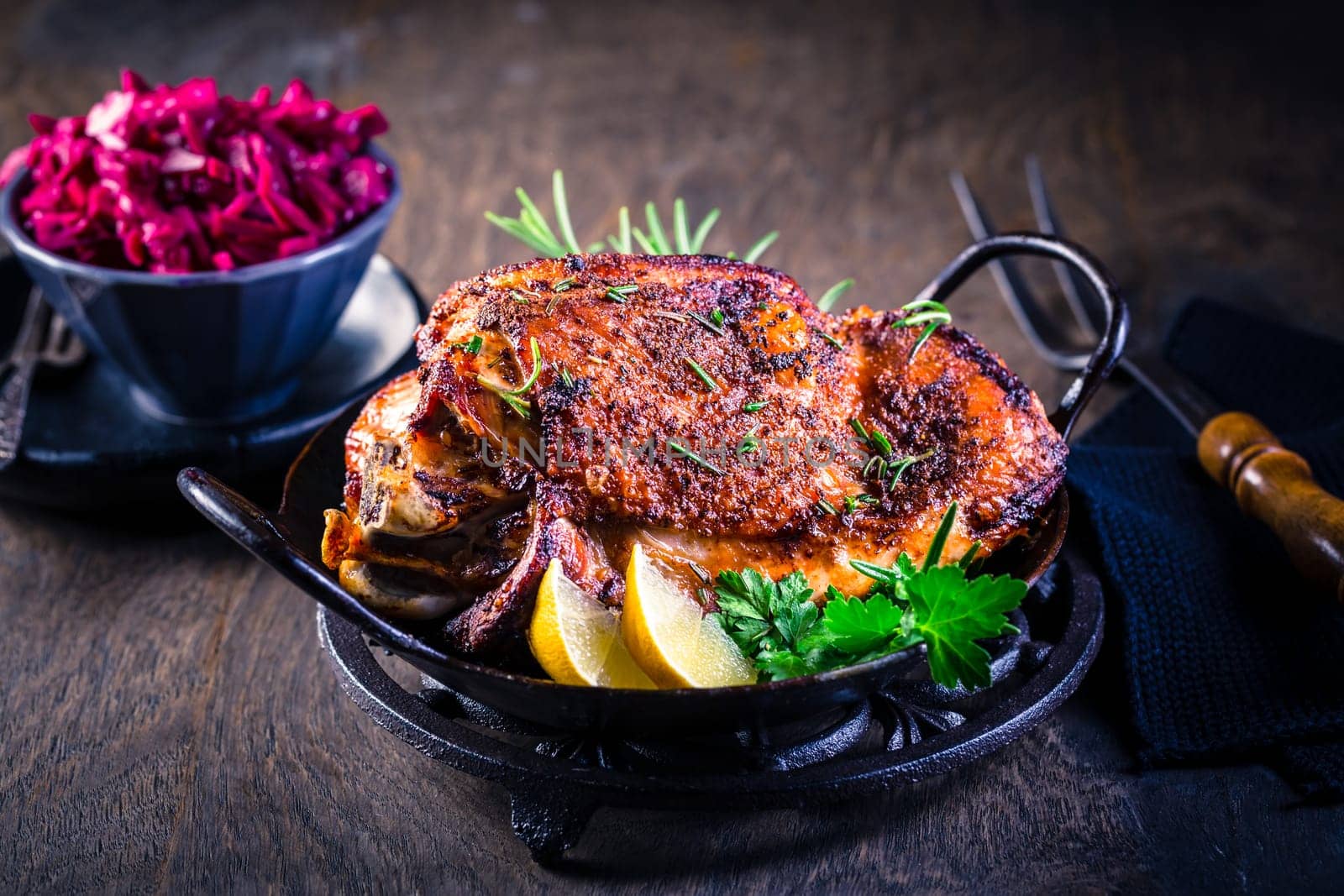 Roasted turkey knuckle with pickled red cabbage salad on wooden background