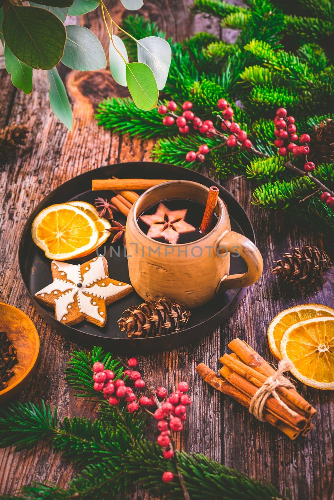 Mulled wine in white rustic mugs with spices and citrus fruit