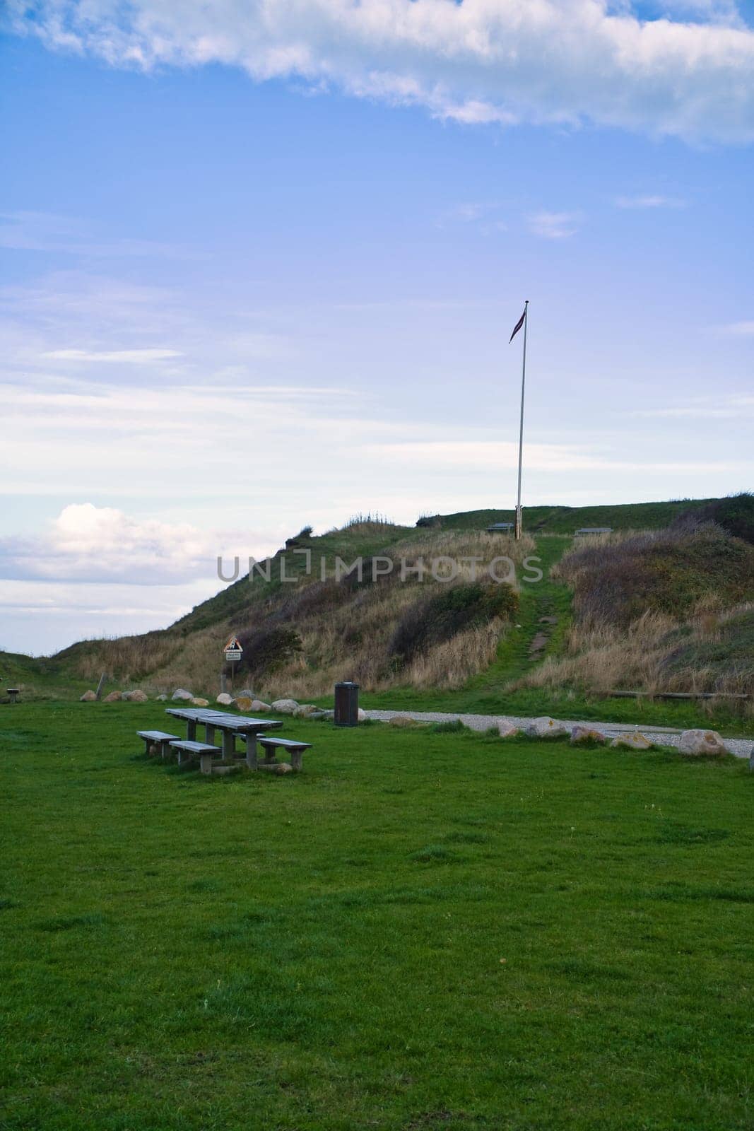 Hundested, Denmark picnic place in front of the cliffs. Flagpole with the Danish flag on the hill. Landscape photo from Scandinavia