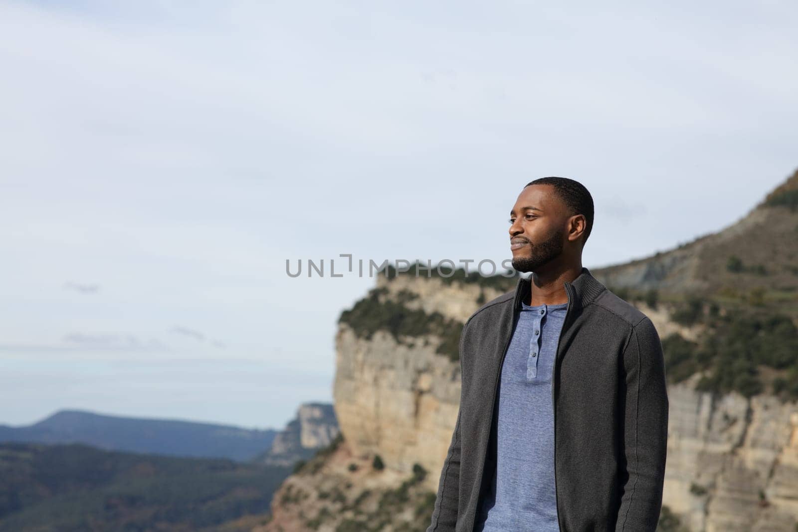 Confident black man contemplating views in the mountain