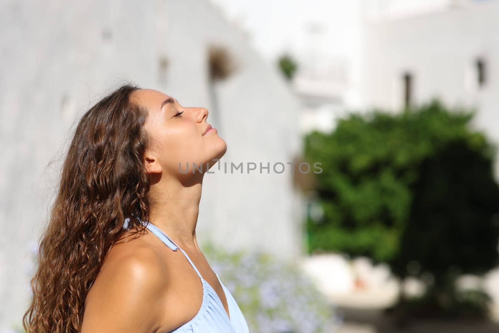 Side view portrait of a woman on summer breathing fresh air in a town