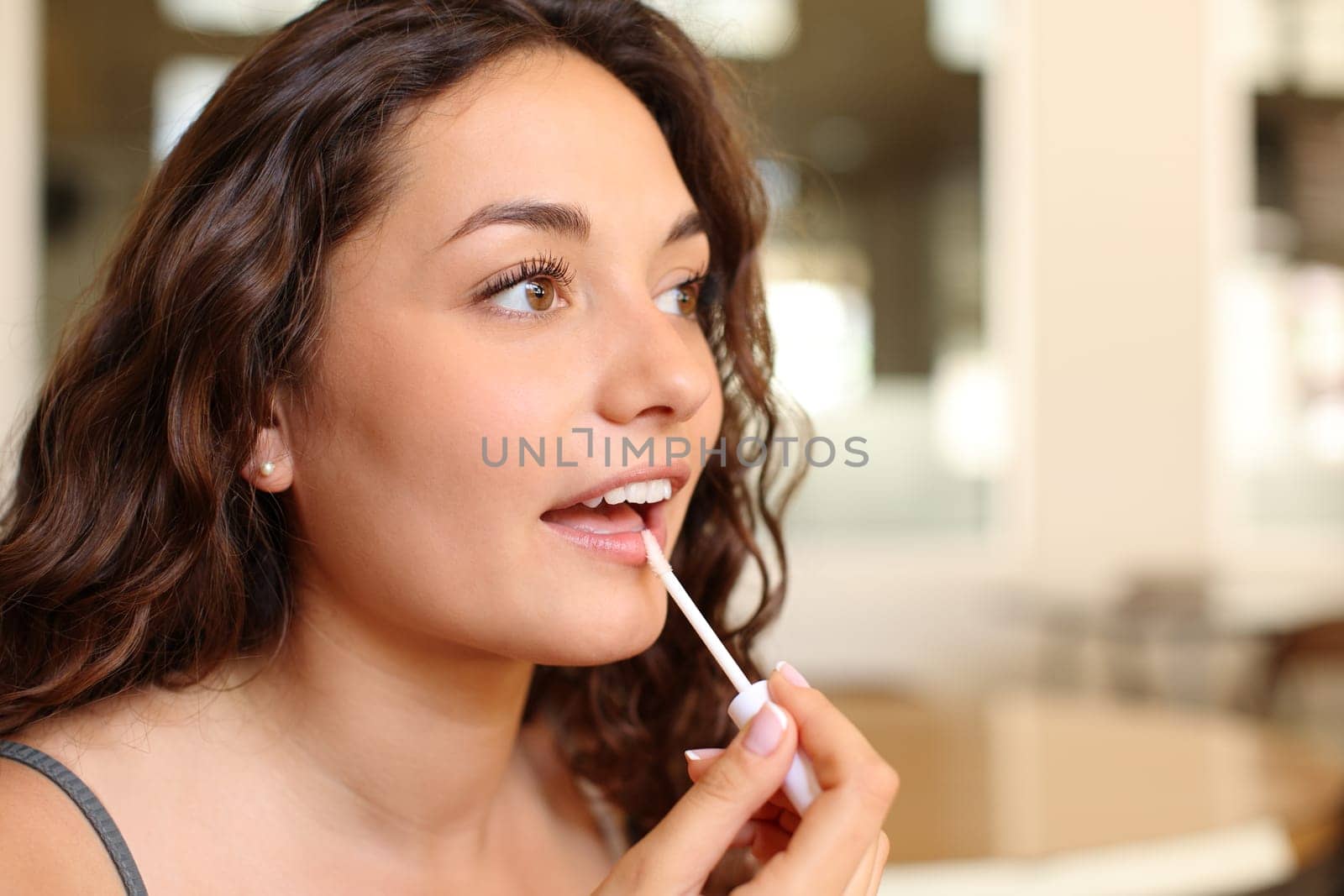 Woman hydrating lips using lipstick in a bar