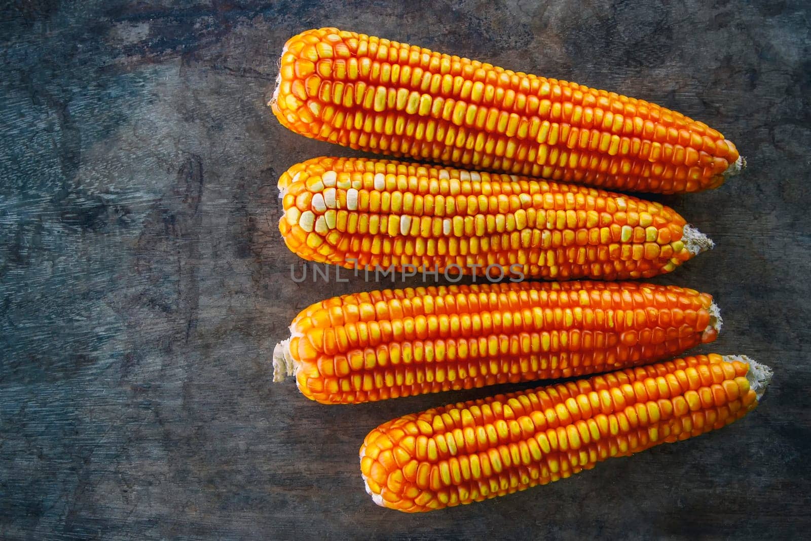 Corn and old wood black background top view.