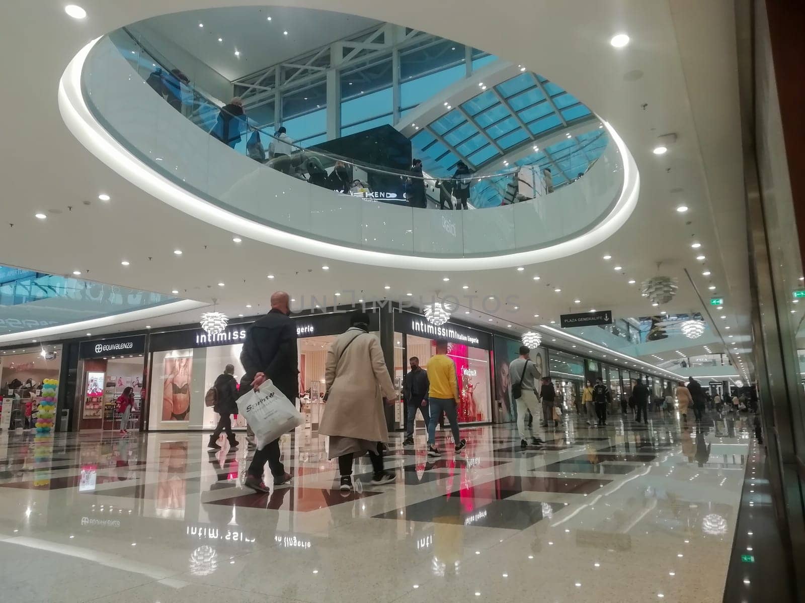 sierra nevada shopping centre, granada spain-december 22 2021: people walking through the large aisles of the Sierra nevada shopping centre during the winter sales in front of the intimissmi shop.