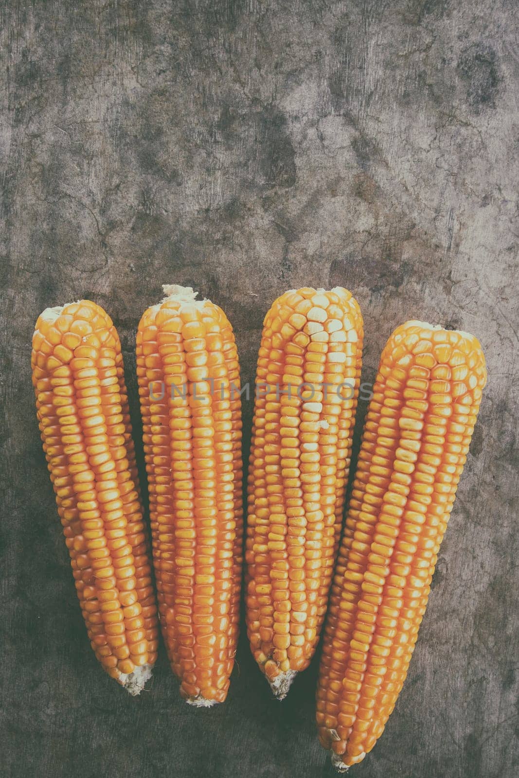 Corn and old wood black background top view.