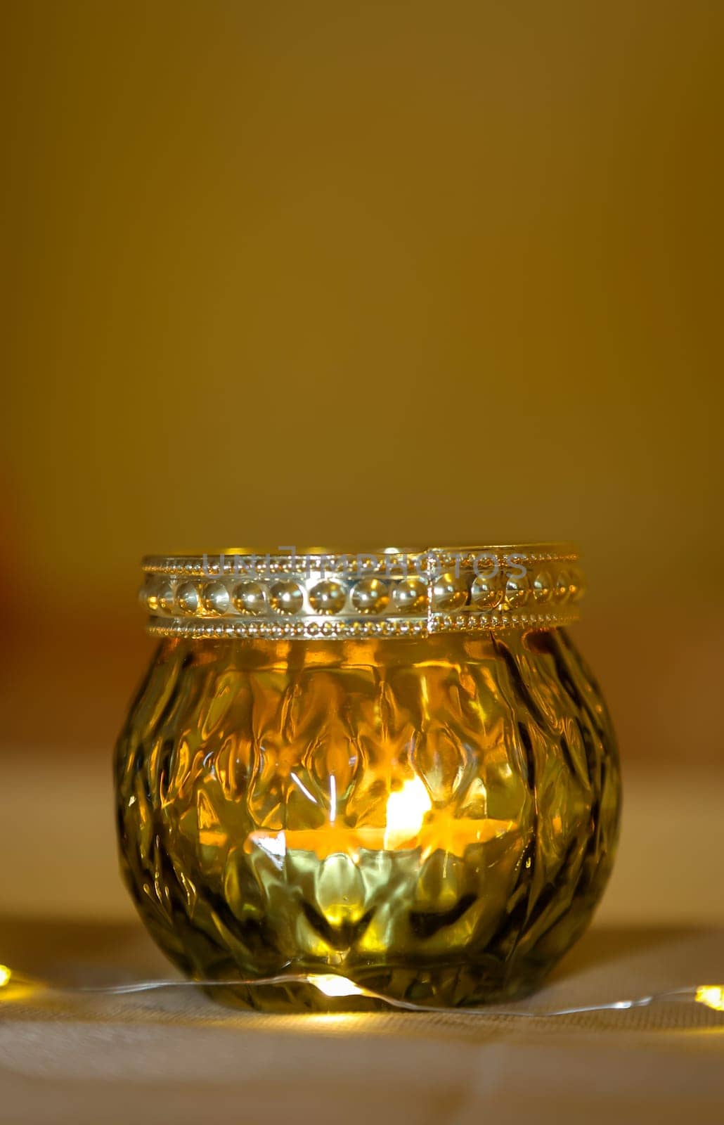 A lantern with a tea light atmospherically illuminates a table in the evening.