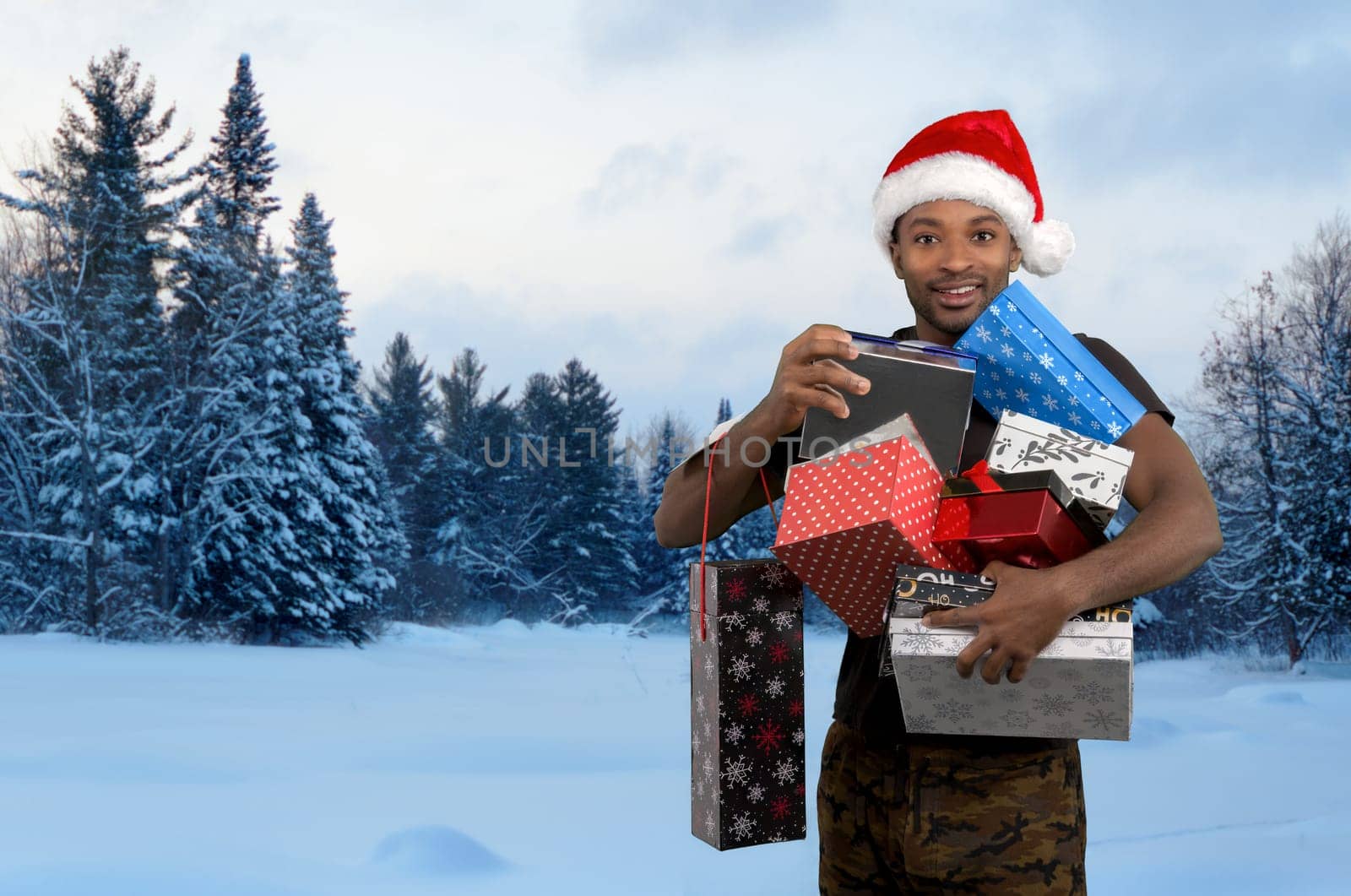 christmas red santa claus hat man holding gifts boxes in the snow fir landscape many presents for holidays