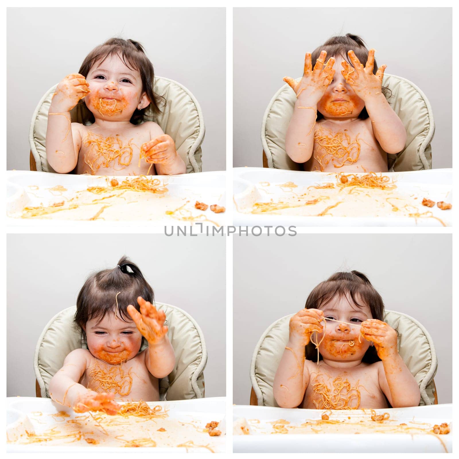 Happy baby having fun eating messy showing hands covered in Spaghetti Angel Hair Pasta red marinara tomato sauce.