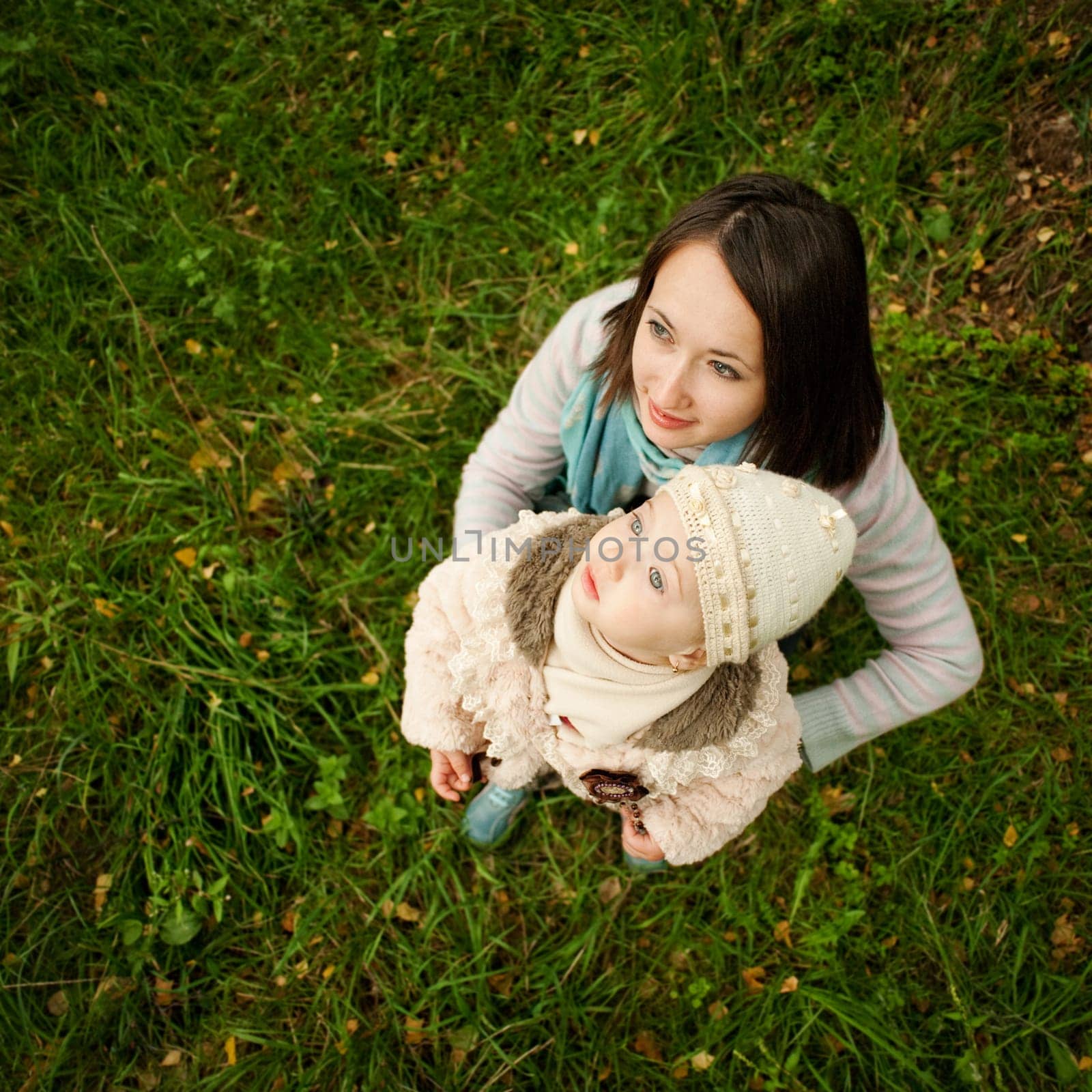 Mother and daughter on a walk looking at the sky while sitting on the grass