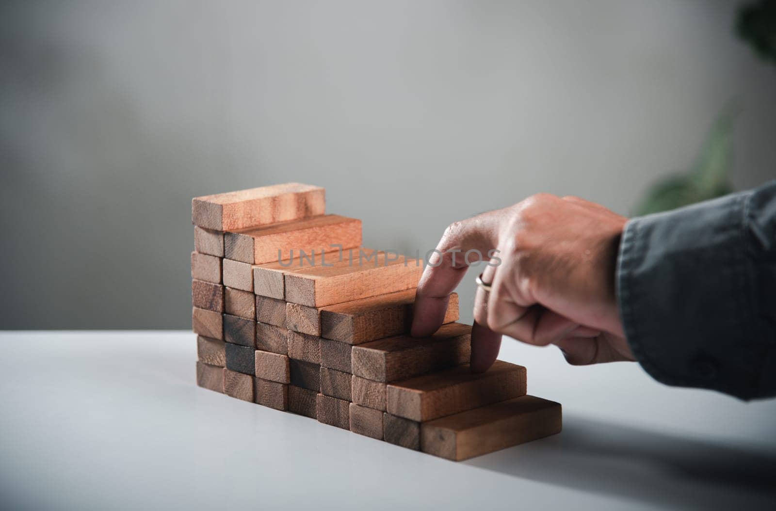 Business two finger symbol walking up on wood blocks shape staircase to climb up career ladder step up stair growth success, prevent collapse or crash concept