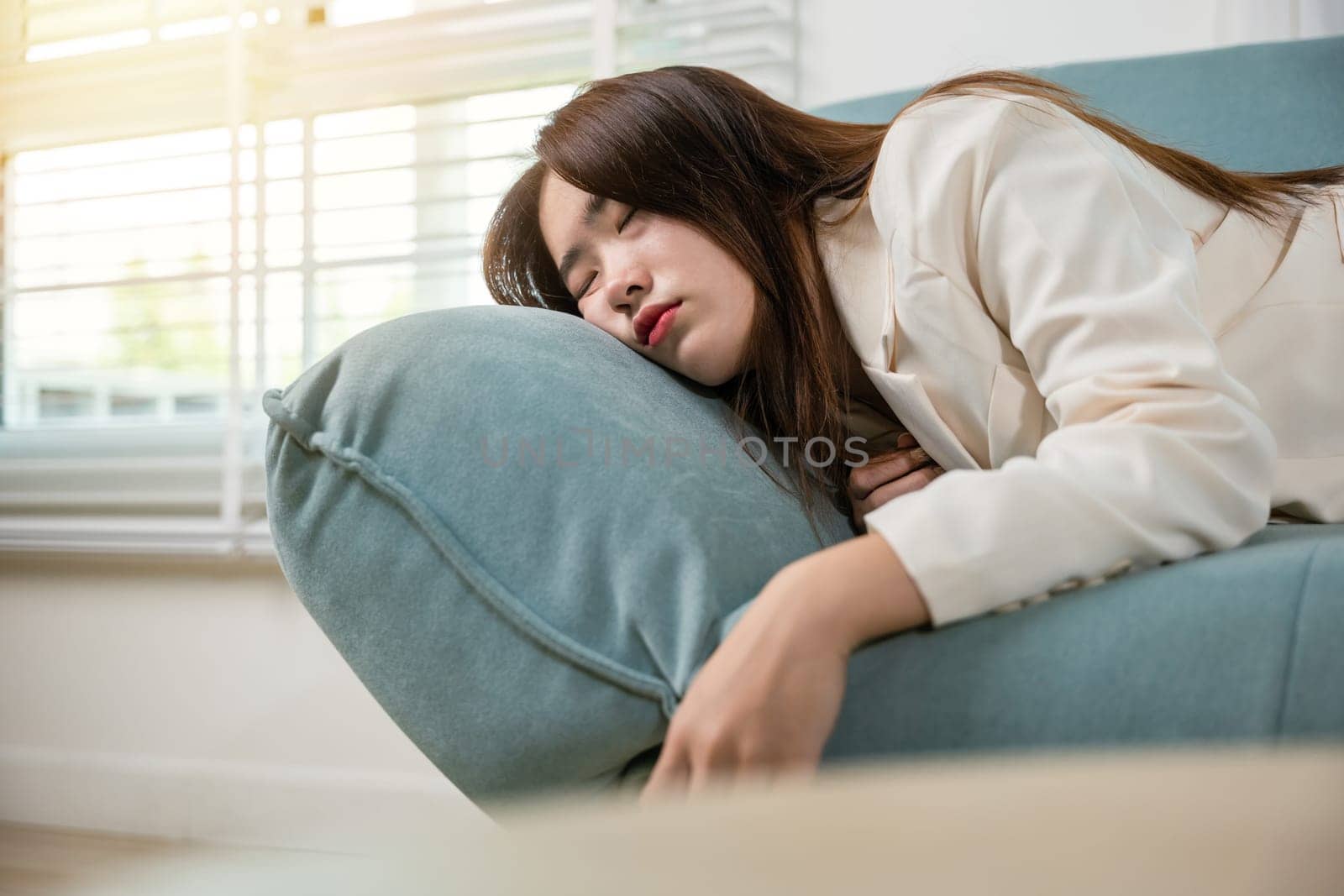 Tired woman sleeping closed eyes on sofa in living room at home after overworked working, Asian female resting falling asleep lying on couch, Close up face